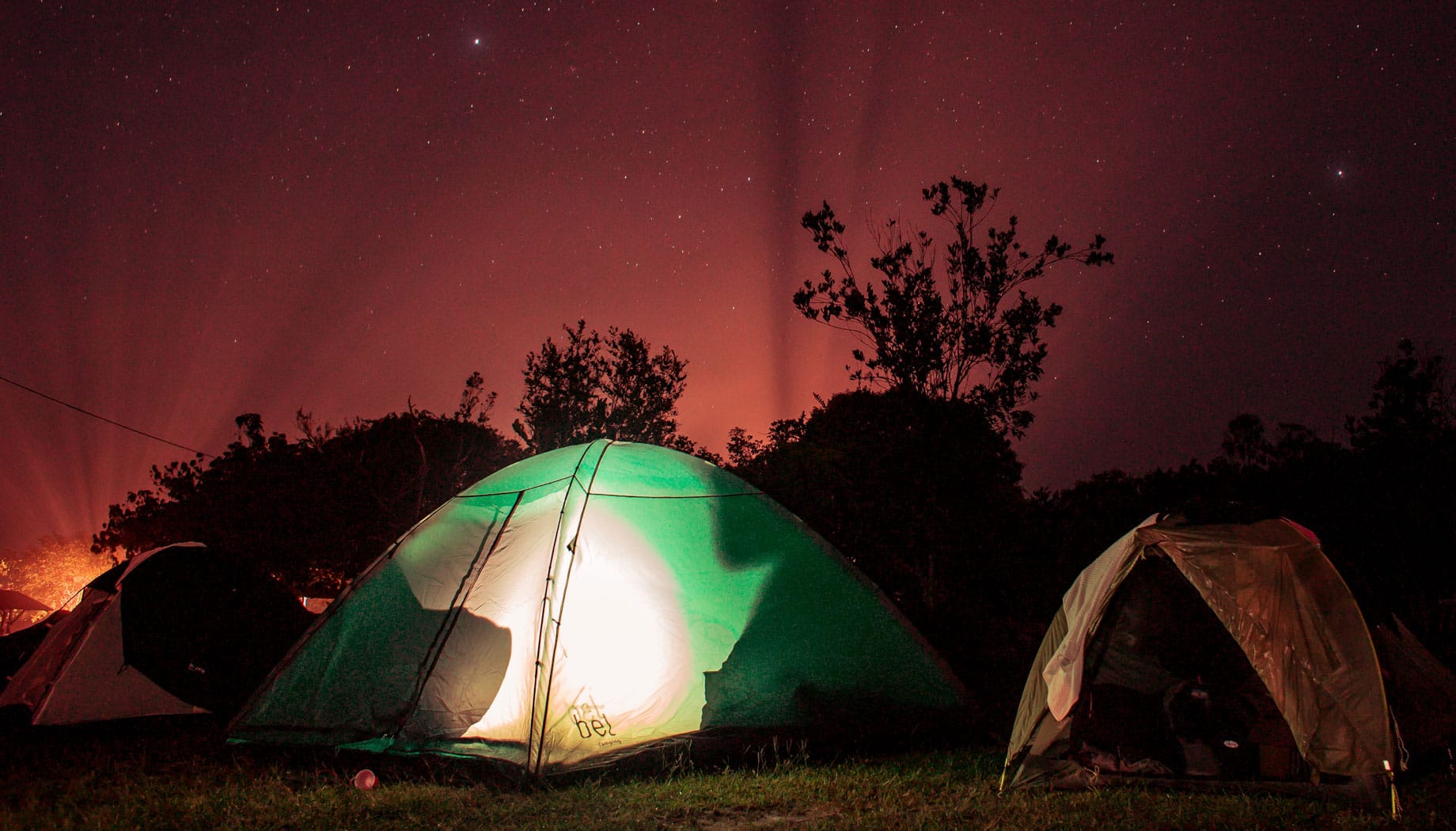camping 09-32-25-688 Three tents camping under a bright night sky.
