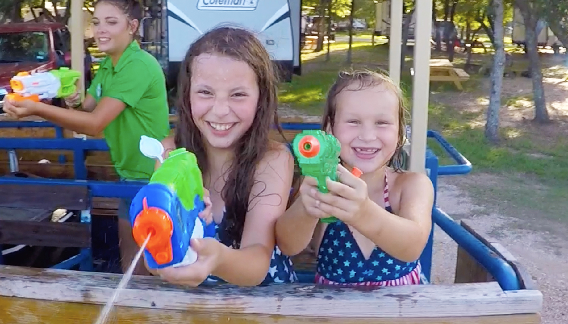 BLOG Two girls holding water guns aimed at the camera.